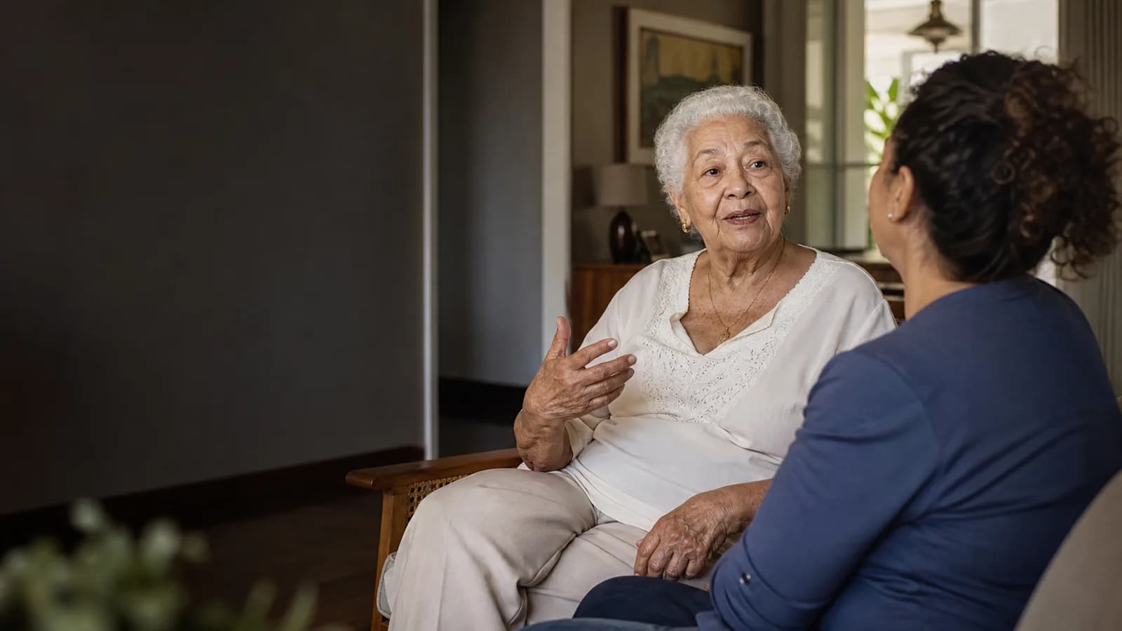 Pessoa idosa contando uma lembrança enquanto um familiar escuta com atenção.