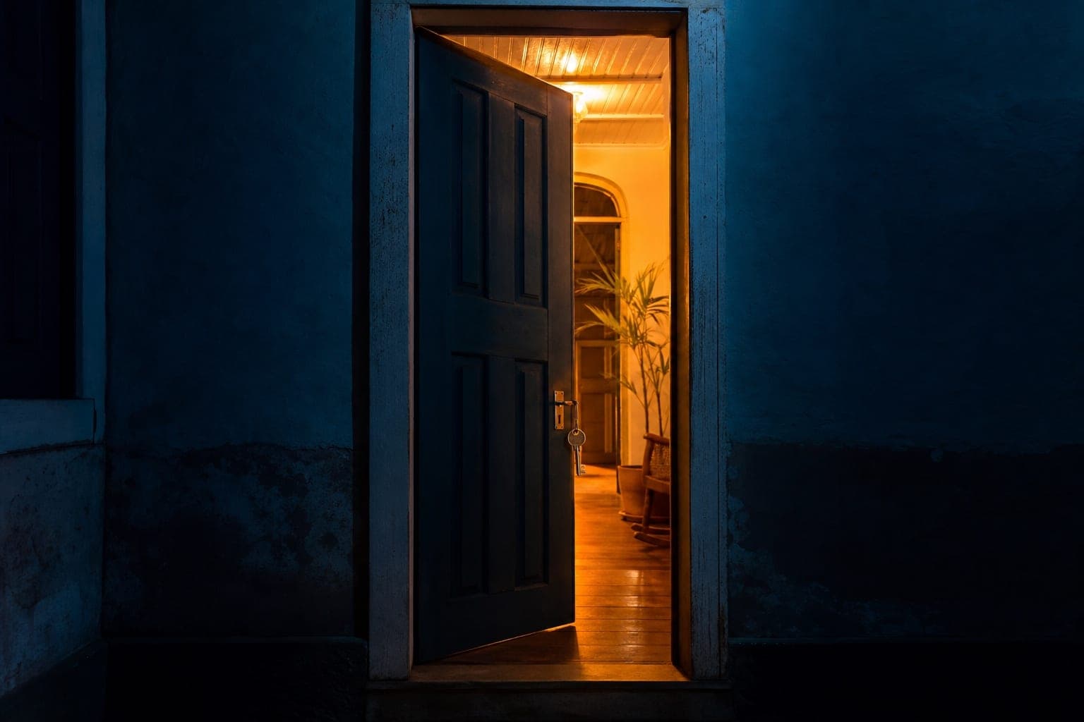 Porta antiga entreaberta com luz dourada e uma chave na fechadura